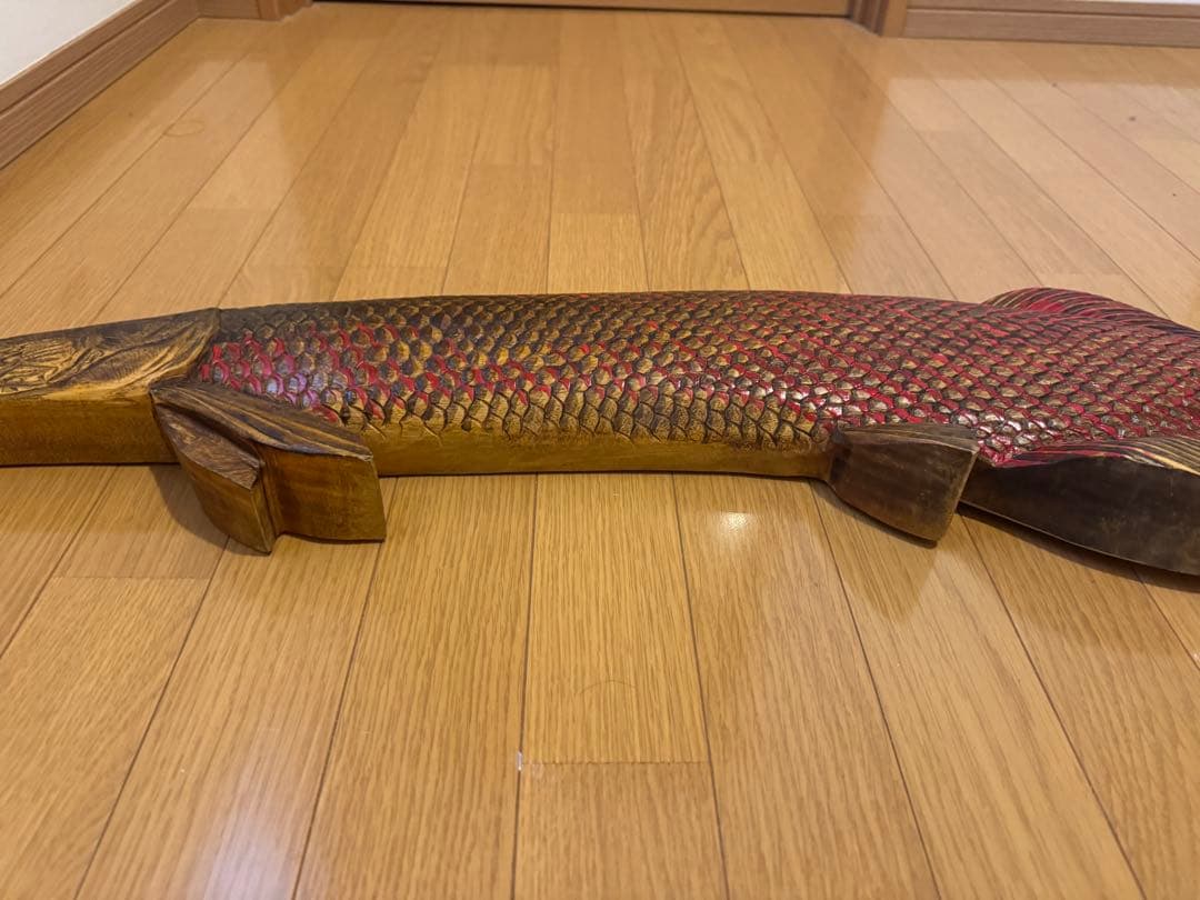 ピラルクの木製彫刻 赤と金の鱗模様